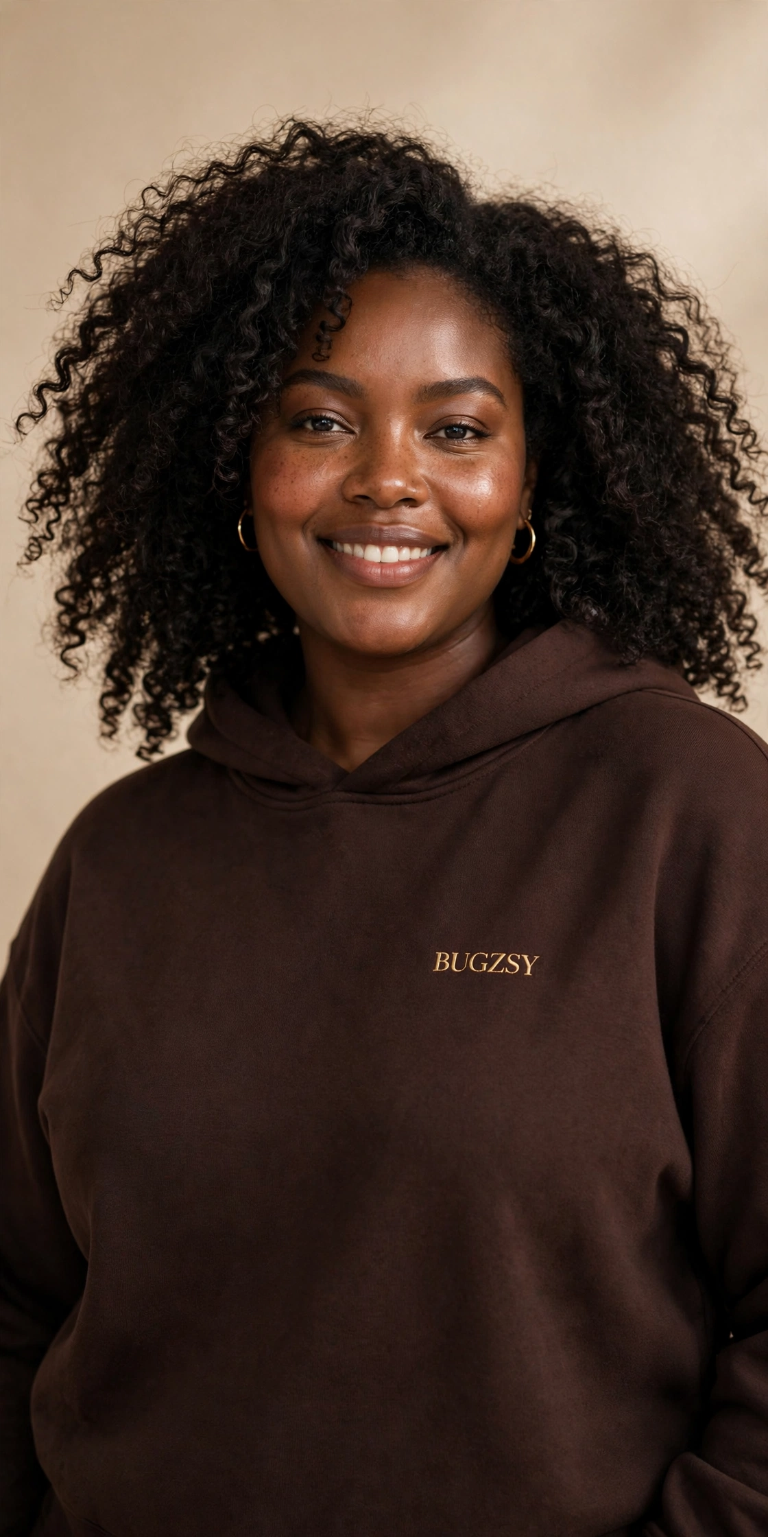 Plus-size Black model smiling in a chocolate Bugzsy hoodie
